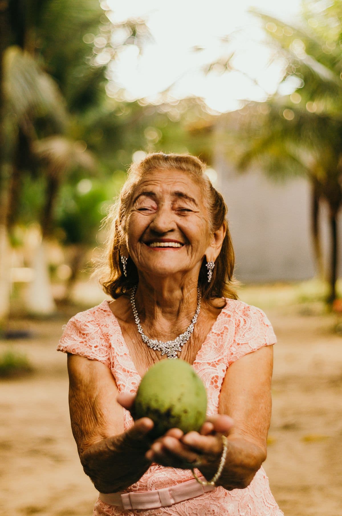 An elderly woman smiling in golden evening light